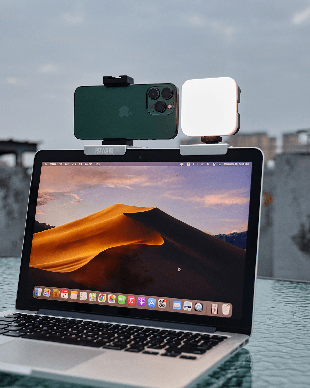 a smartphon and a video light mount on the macbook monitor for video conference