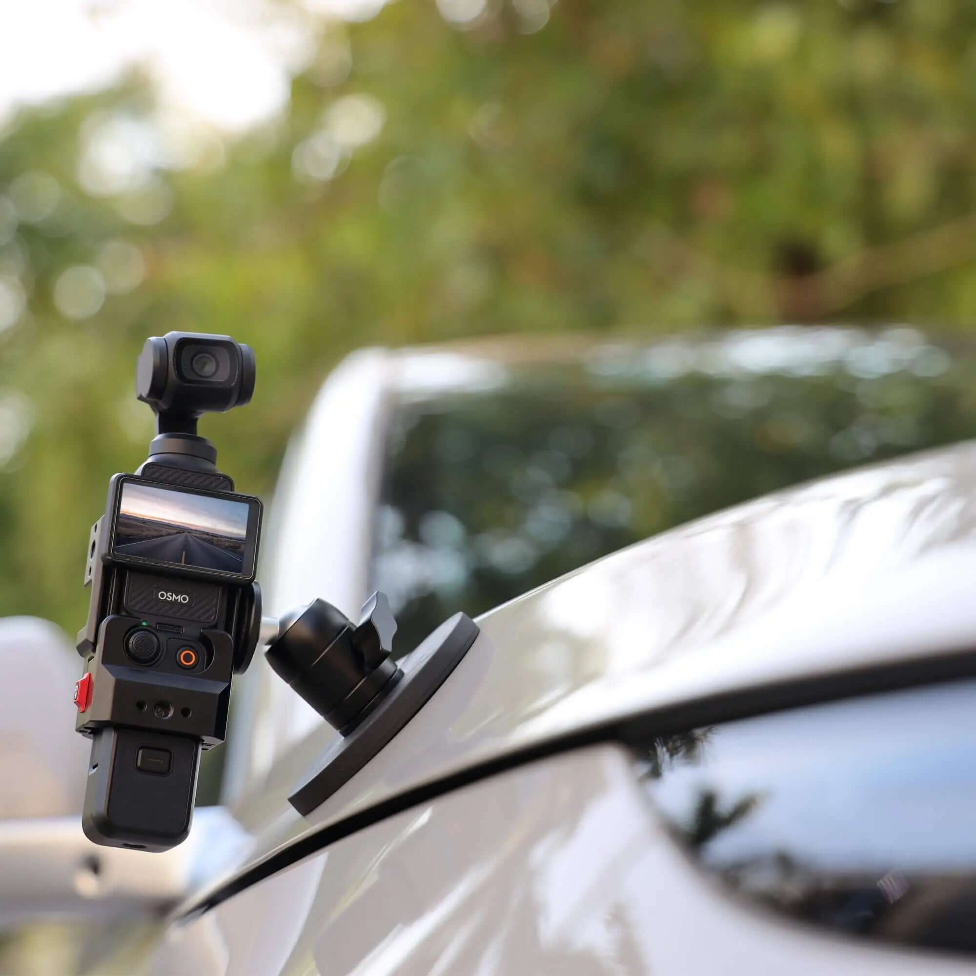 Action shot of DJI Osmo Pocket 3 attached to the magnetic mount on a car hood for video production